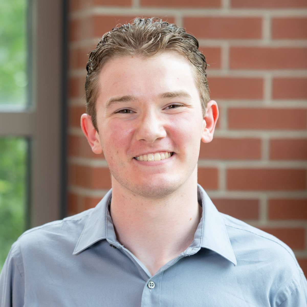 With short hair and a collared shirt, Trent smiles for the camera.