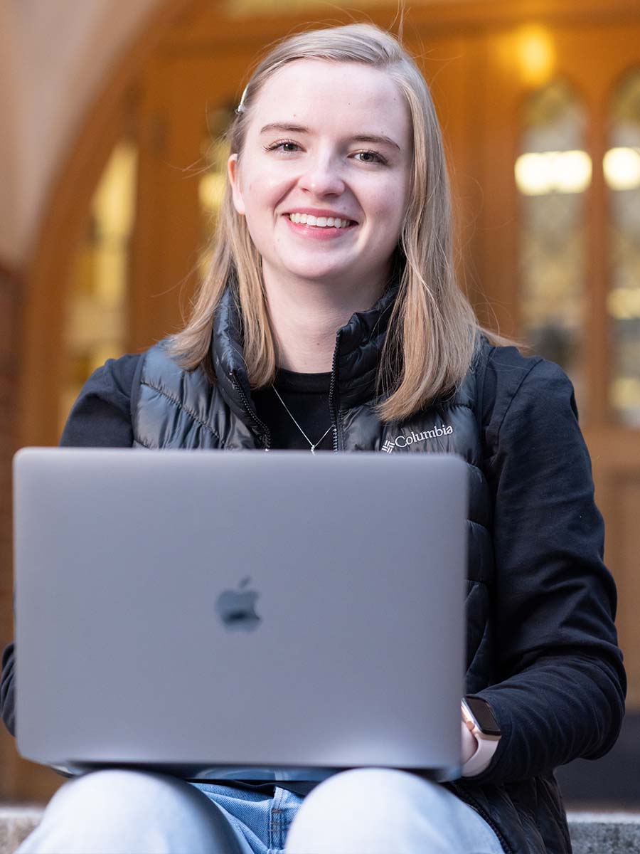 Grace Meyer sits with computer on her lap