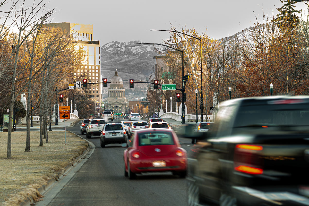 Cars, in motion blur, drive down a street in downtown Boise with the state Capitol at the end.