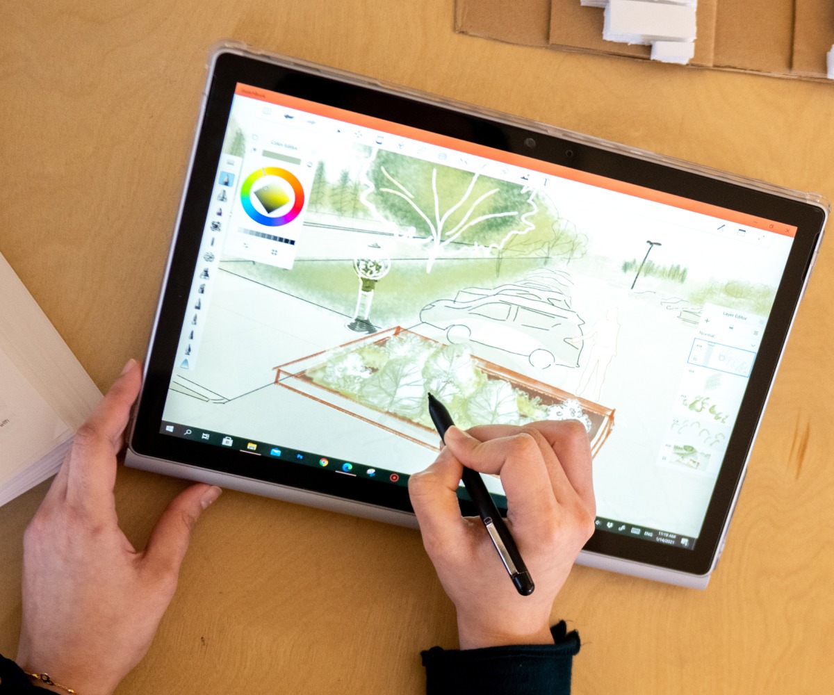 Layal Hussain draws a parking lot on her tablet with trees and other greenery.