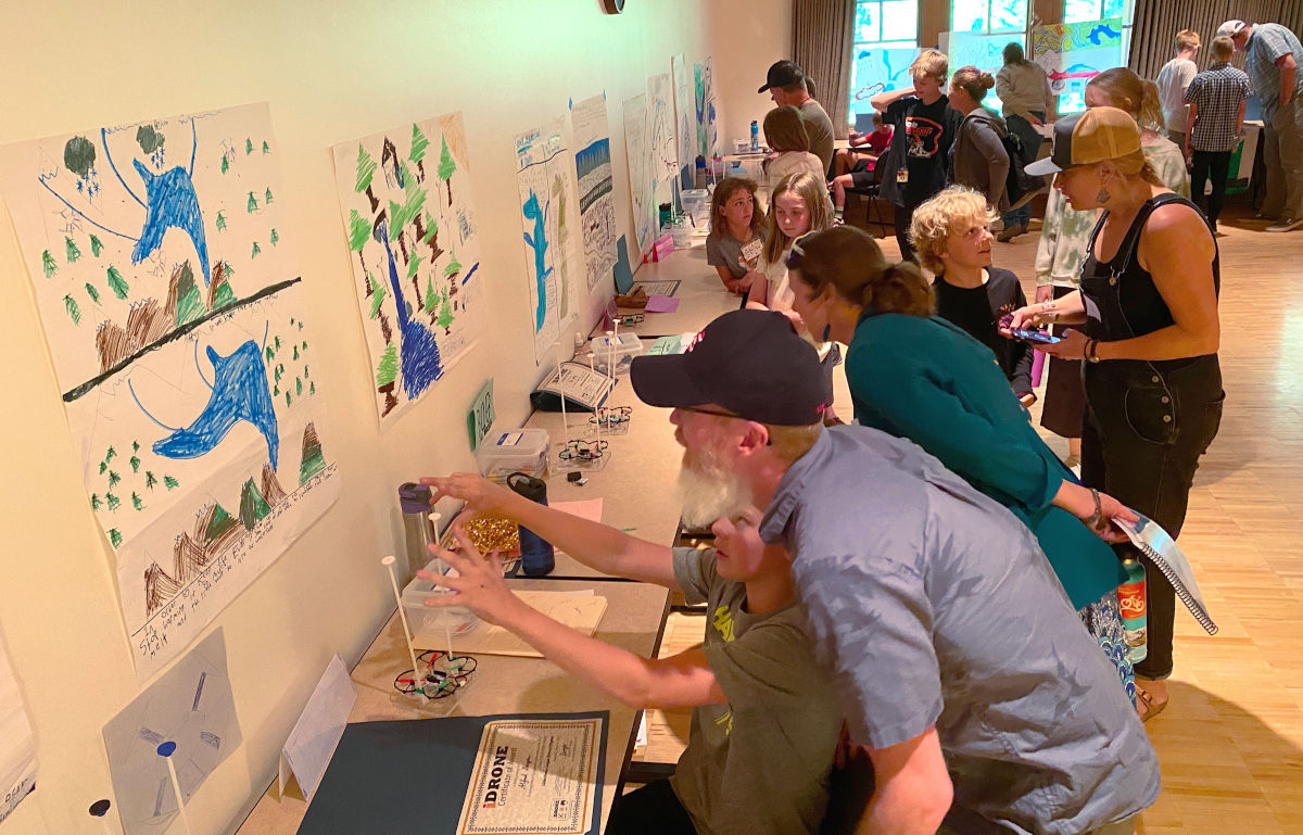 Parents and students looking at posters in a large room.