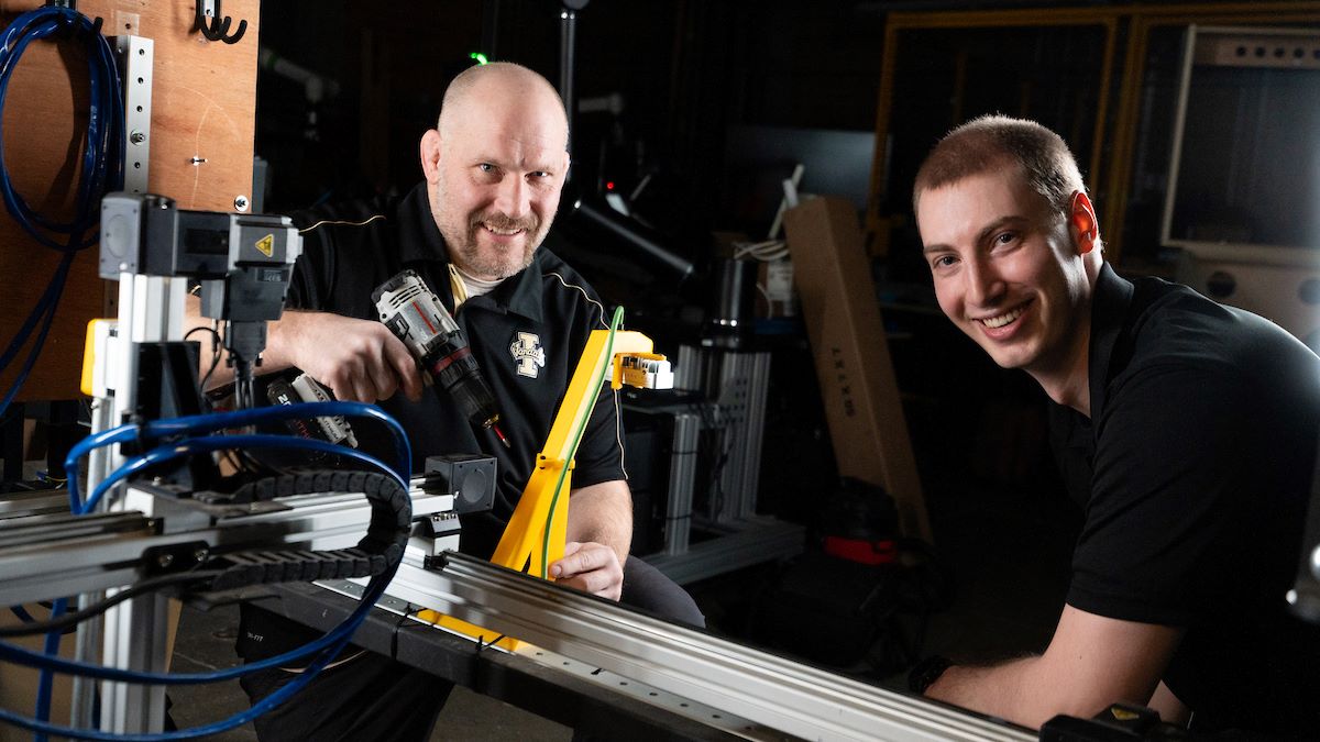 Brent Knopp, left, and Garrett Wells, right with the team's weeding robot.