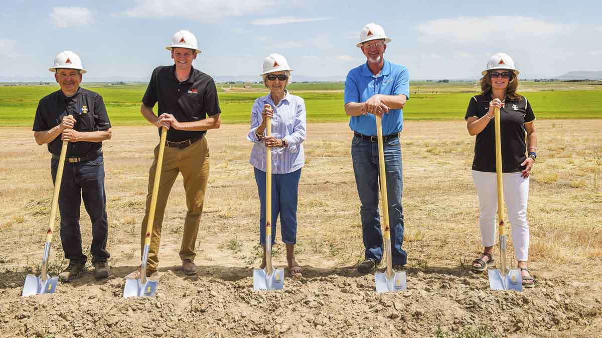 Group photo of men and women holding shovels.